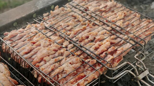 close-up of freshly grilled chicken sizzling on a metal grill grate over a wooden surface