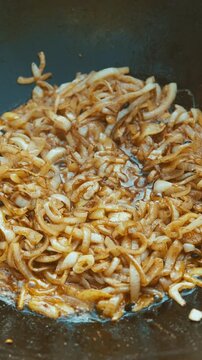 a neutral frying scene in the kitchen with carrots being cooked in a pan, oil and shredded food visiblea.