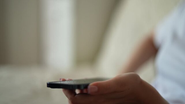 Close-up shot of person spraying and wiping modern smartphone. Woman using microfiber cloth to cleaning camera lens, ensuring device sanitized and free of germs. Concept of hygiene and tech care.