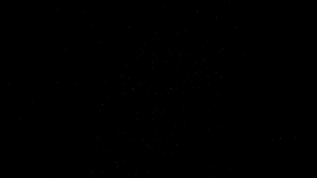 Abstract particles float in total darkness creating a subtle atmospheric effect for cinematic background design.
