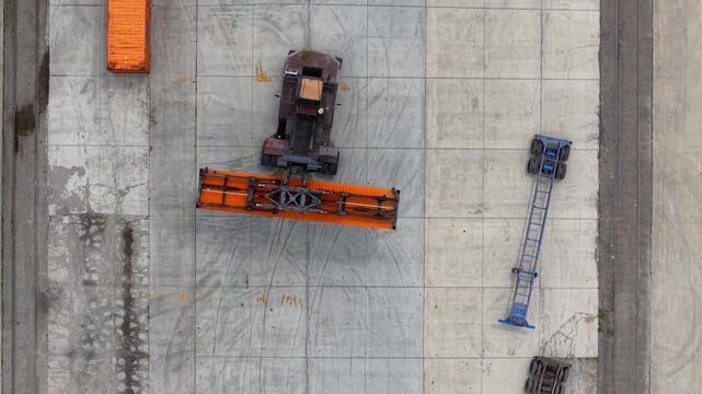 Reach stacker handling a shipping container aerial top down view