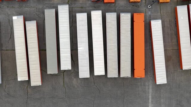 Top down aerial view of semi trailers parking in a lot