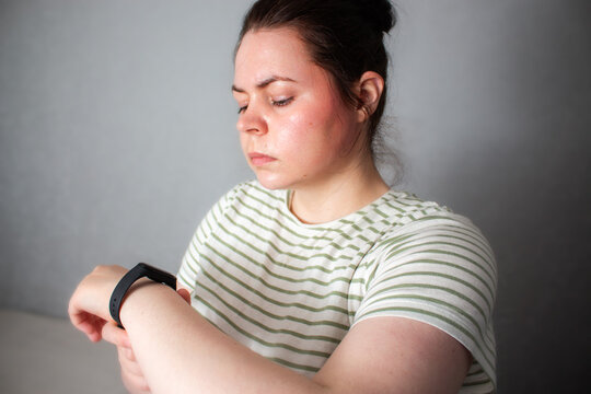 Woman checks health rhythm and pulse then puts watch to sleep. No obsession about data checking. Moving from rigid self-tracking to intuitive balanced tech use