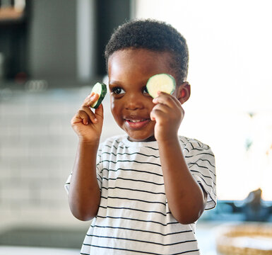 Portrait of little boy child preparing a meal and having fun in the kitchen at home