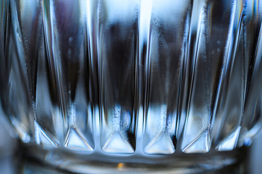 Extreme macro of faceted glass texture with reflective highlights.