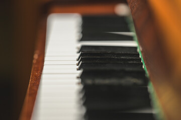 Moody closeup of old piano keys with dark shadows. © Trygve