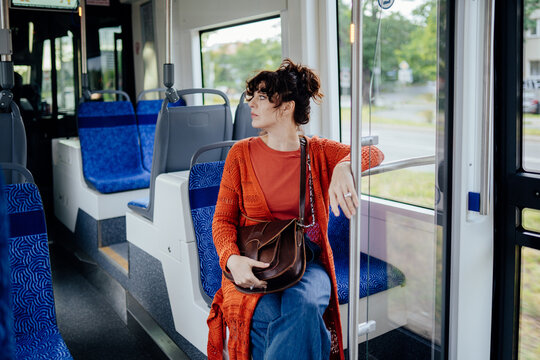 Attentive young woman watching her tram stop during everyday urban commute