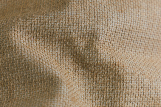 Close up view of a textured fabric background showing woven details and natural colors in simple patterns