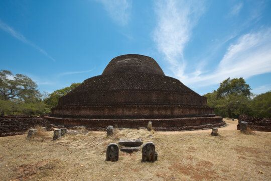 Ancient Buddhist dagoba (stupe) Pabula Vihara in Ancient city of Polonnaruwa, Sri Lanka, with Buddha