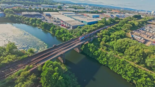 Drone footage of train crossing rail bridge over river Ely in Cardiff