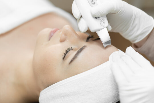 Closeup of female client undergoing ultrasonic face cleansing by skilled esthetician in spa setting. Innovative beauty technology enhances skin texture and promotes a healthy, glowing complexion