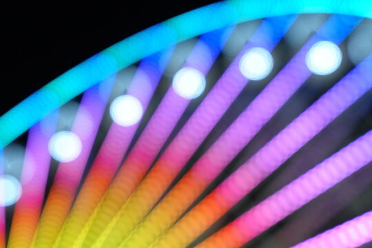 Soft focus bokeh of colorful lights on a ferris wheel at night