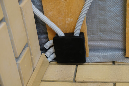 Junction box on the ceiling with wires connected. The wiring assembly is being installed.