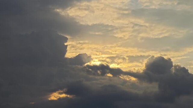 Dramatic cumulus clouds moving slowly under golden sunset light with a 3D depth effect, concept of heavenly divine glow, spiritual hope, atmospheric weather transformation and peaceful meditation back