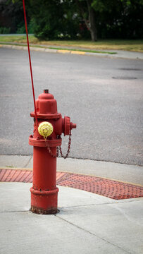 Red fire hydrant with yellow cap on sidewalk. Infrastructure and safety design element with banner or background.