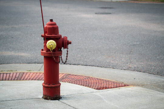 Red fire hydrant with yellow cap on sidewalk. Infrastructure and safety design element with copy space.