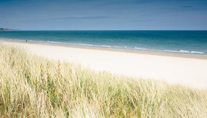 Fotobehang Duinen Curracloe Beach. Wide sandy beach with dune grass foreground, lone figure walking along the shoreline, calm turquoise sea meeting pale sand, Curracloe Beach, County Wexford, Ireland  © helen