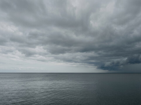 Paisaje marino con cielo gris nublado y horizonte calmo con espacio para texto
