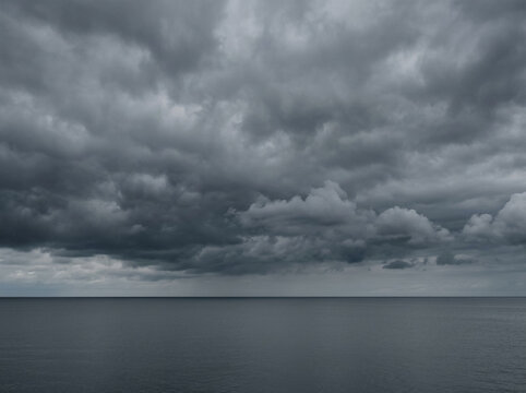 Paisaje marino con cielo gris nublado y horizonte calmo con espacio para texto