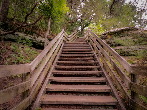 Steep wooden staircase climbing a rocky forest hillside along a hiking trail