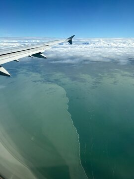brackish water meets marine water: aerial view of the sharp demarcation between silty freshwater of the Fraser River and saltwater in the Strait of Georgia near Vancouver, British Columbia