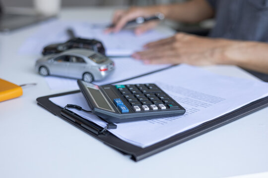 Businessman Reviewing Documents to Compare Vehicle Investment and Expenses.
