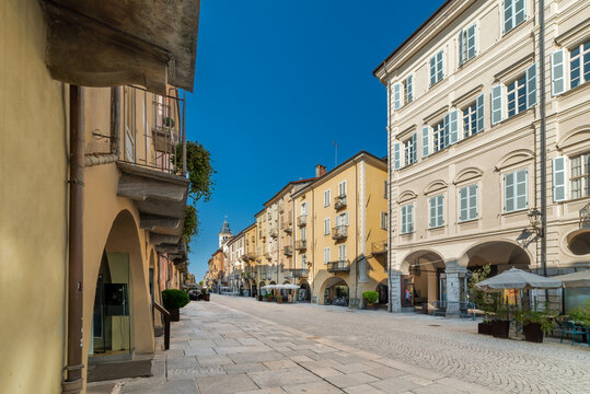 Scenic view of the historic Via Roma in Cuneo, Piedmont, Italy. Pedestrian street features traditional cobblestone pavement, elegant old buildings with pastel facades,characteristic arcaded walkways