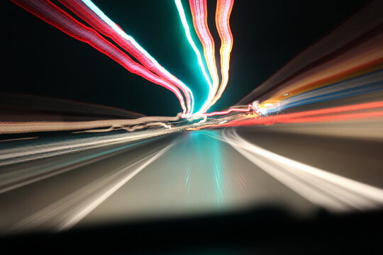 Abstract speed motion in urban highway road. Fast moving traffic light trails at night.