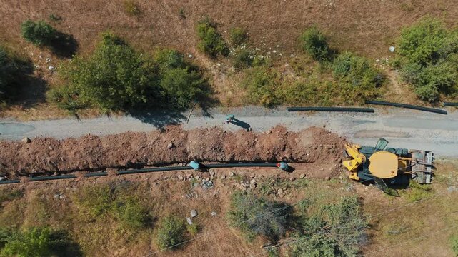 Aerial view of workers laying pipes and heavy machinery