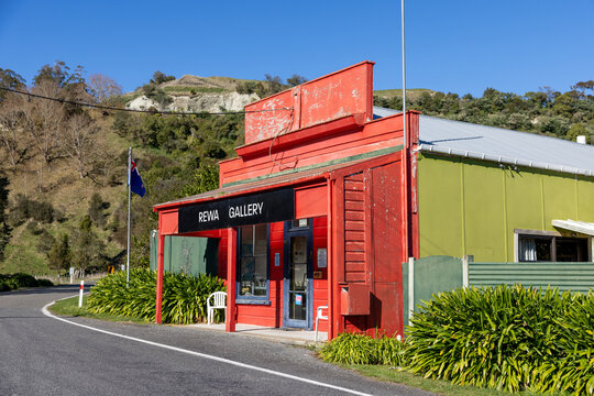 REWA, NEW ZEALAND &ndash; OCTOBER 2023: The exterior of the bright red Rewa Gallery building set against rolling green hills in rural NZ.