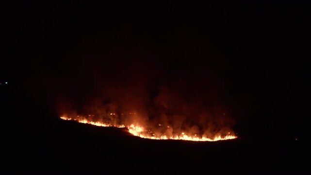 Line of fire cuts the hill in two in the night