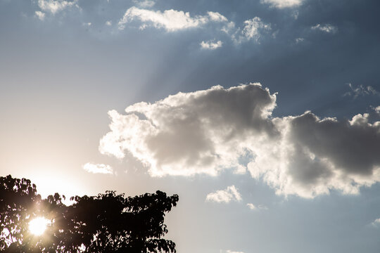 C&eacute;u com nuvens e raios de sol durante o final da tarde.