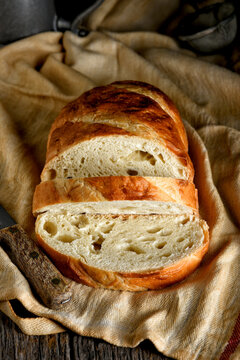 Bread still life. A fresh loaf of Bread in a rustic kitchen setting with two slices cut.