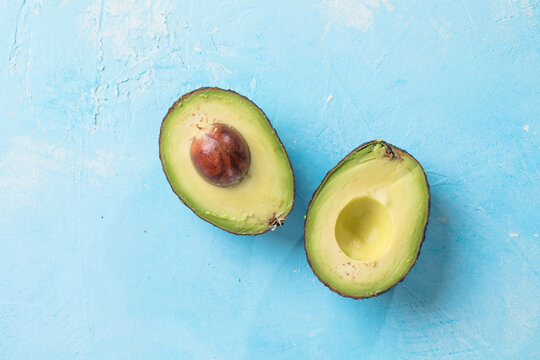 Avocado on a blue background. Cut avocado