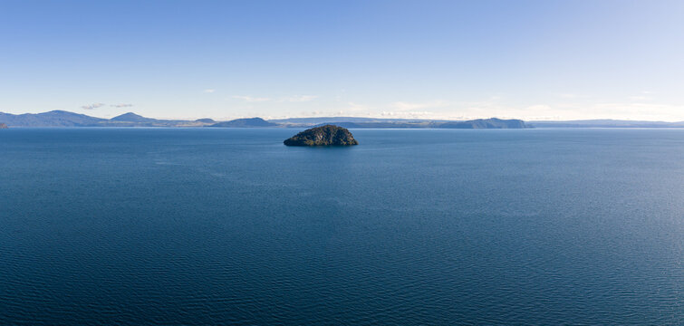 A scenic panoramic view of Motutaiko Island sitting in the middle of the expansive Lake Taupo in the Taupo District of New Zealand.