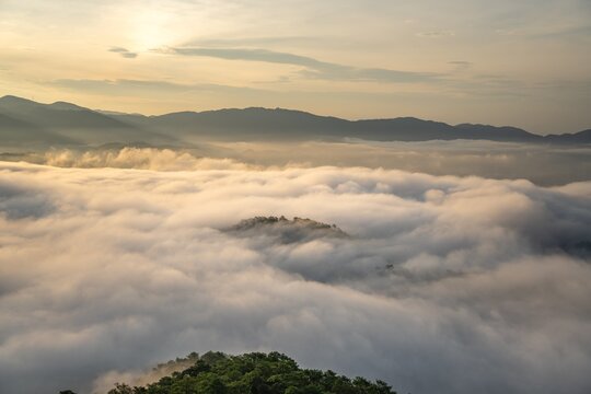 Sea of clouds rolling over mountain ridges at sunrise