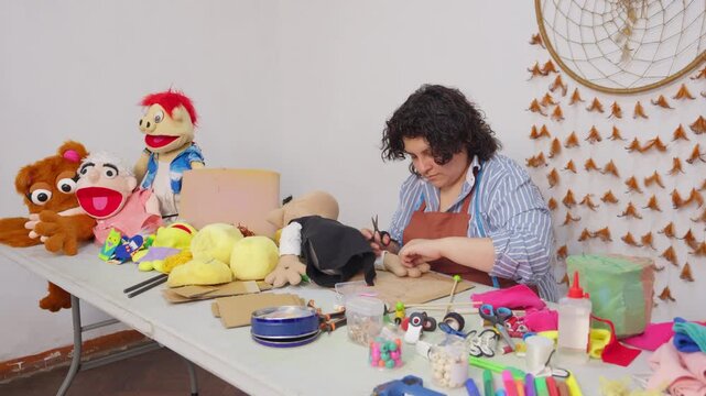 Focused artisan creating handmade puppets in workshop