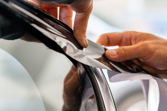 A car wrapping specialist applies a polyurethane film to the car. Detailer PPF
