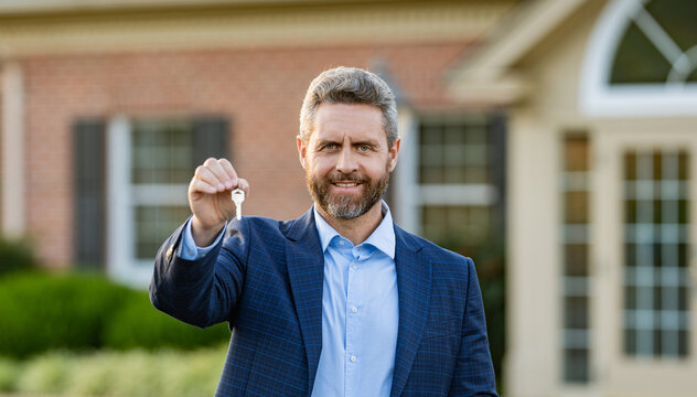 House insurance. Realtor offering new home. Realtor in suit hold key outdoor. Real estate agent showing house for sale. Property insurance. Real estate market. Broker man giving key