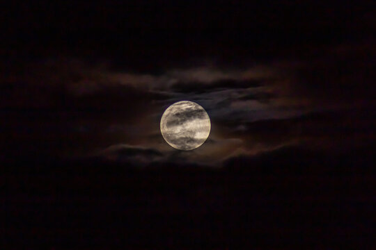 Full moon in the night sky with clouds