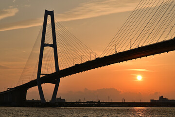 Obraz premium 夕日に照らされた名港中央大橋