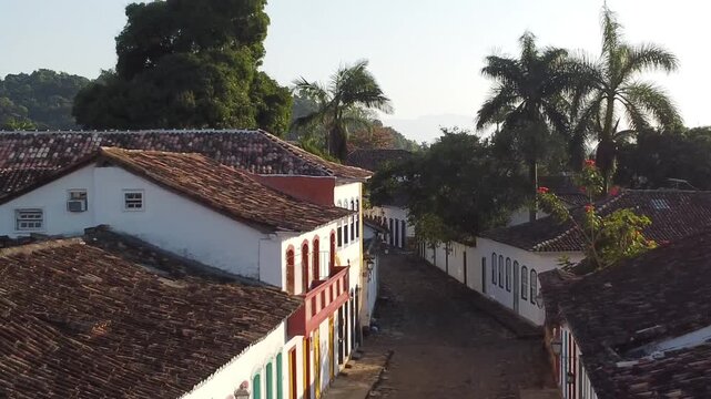 Drone flyback above colonial street in historic Paraty at golden hour, Brazil