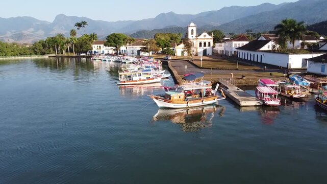 Low aerial flight past boats and colonial waterfront in Paraty