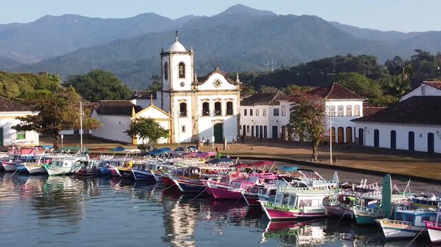 Colorful boats and Saint Rita Church in Paraty morning light
