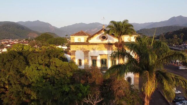 Drone flyover revealing Igreja Matriz de Nossa Senhora dos Rem&eacute;dios at sunrise in Paraty, Rio de Janeiro, Brazil