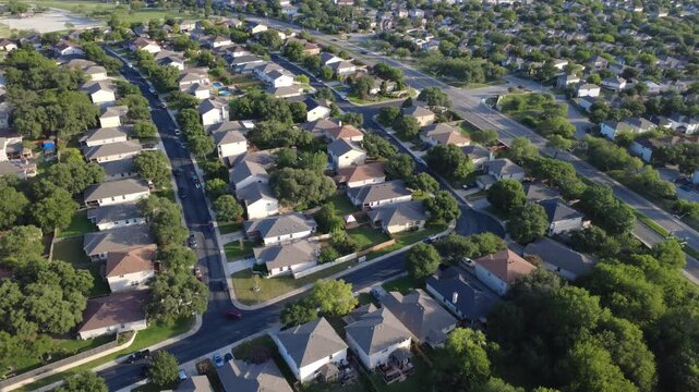 Magnolia Crest Drive intersects master planned community single family suburban houses near West Military Drive. Asphalt roads parallel dense housing developments oak canopies, San Antonio, TX