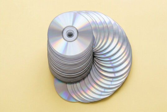 Large stack of iridescent compact discs arranged in a fanned spiral pattern