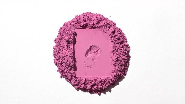 Overhead capture of a pile of pink powder with a rectangular trace on a gentle grey background, highlighted by rotating directional light producing changing shadows | Blush marketing concept