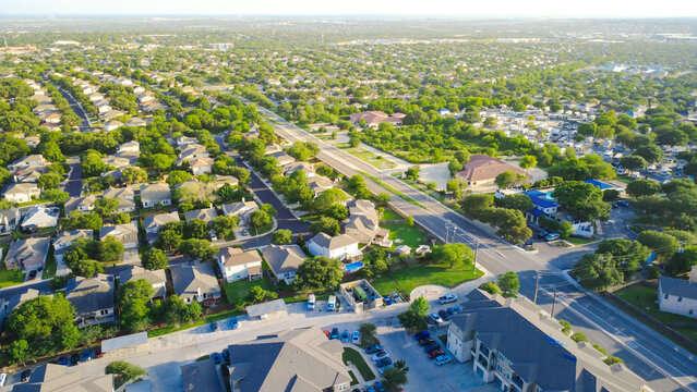 North Ellison Drive intersection joins master planned community dense housing near West Military Drive. Suburban houses border retail centers and multi-family residential units, San Antonio, TX