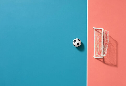 Minimalist Soccer Ball and Goalpost Composition with Blue and Pink Split Background Representing Playful Sports Theme